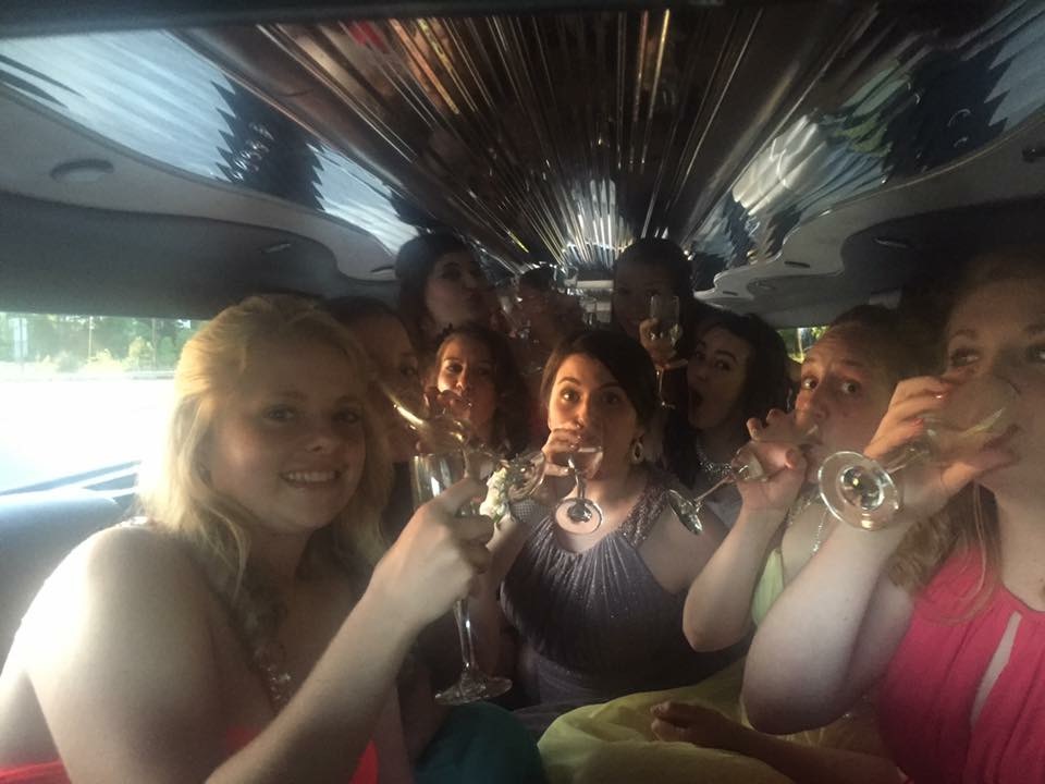 Charlotte Prom Limo drinking grape sparkling juice out of champagne flutes for fun in the silver hummer limo